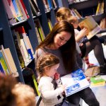 Volwassenen lezen kinderen voor in de bibliotheek